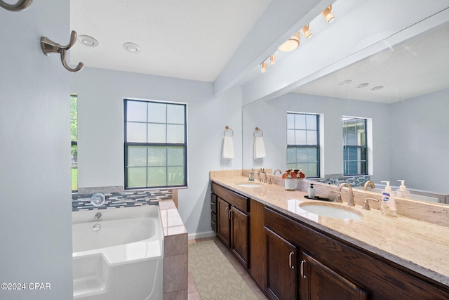 bathroom featuring a healthy amount of sunlight, vanity, a bath, and tile patterned flooring