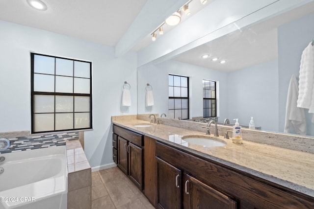 bathroom with a wealth of natural light, vanity, a bath, and tile patterned flooring