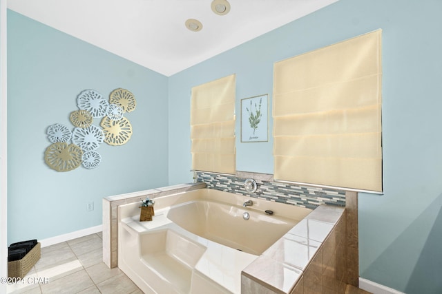 bathroom with tile patterned flooring, backsplash, and a washtub