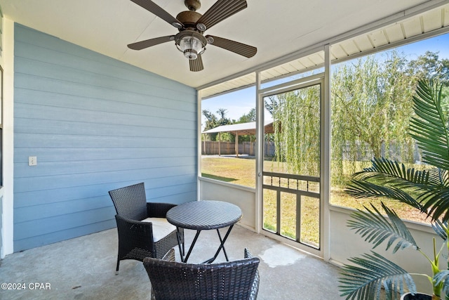 sunroom with ceiling fan and vaulted ceiling