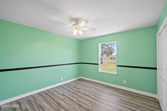 unfurnished room with hardwood / wood-style floors, a textured ceiling, and ceiling fan