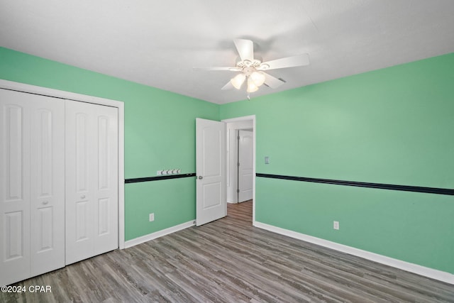 unfurnished bedroom featuring a closet, hardwood / wood-style floors, and ceiling fan