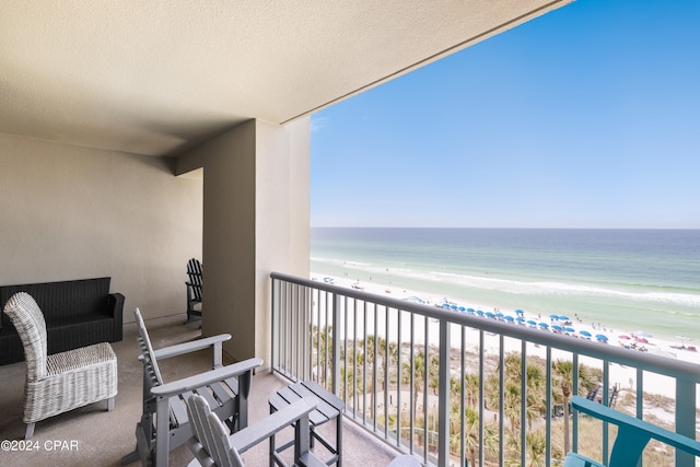 balcony featuring a water view and a view of the beach