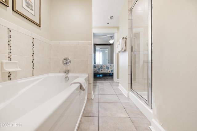 bathroom featuring shower with separate bathtub and tile flooring