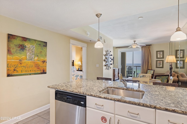 kitchen with hanging light fixtures, white cabinets, light tile floors, sink, and dishwasher