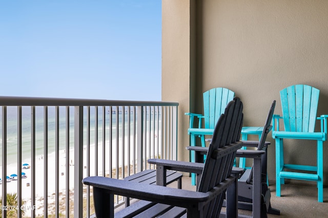 balcony featuring a water view and a view of the beach