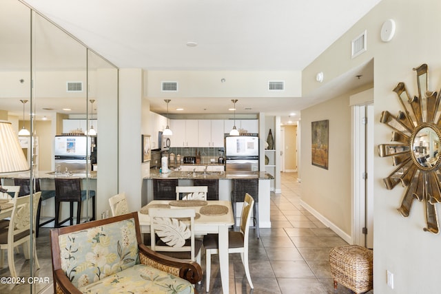 dining space with tile flooring