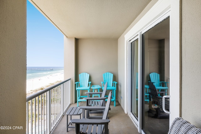 balcony featuring a beach view and a water view