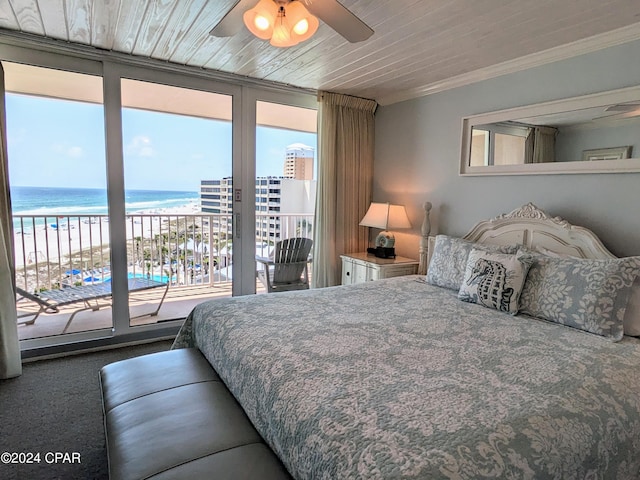 bedroom featuring a wall of windows, access to outside, a water view, and ornamental molding