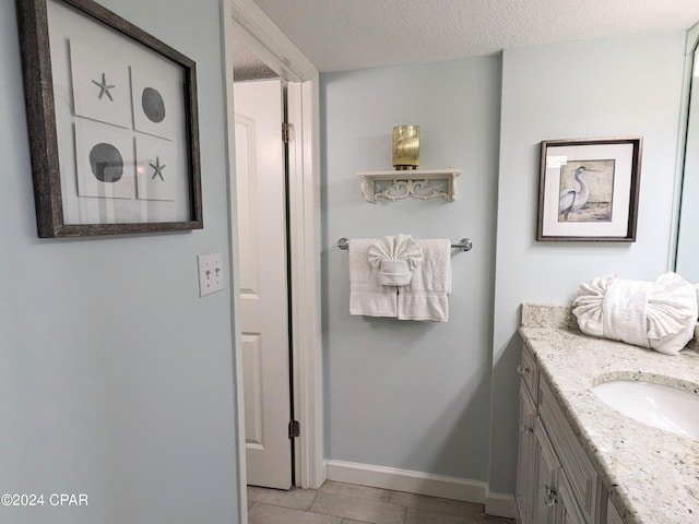 bathroom featuring baseboards, a textured ceiling, vanity, and tile patterned floors