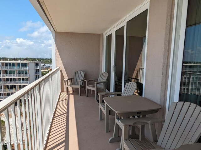 balcony featuring a beach view and a water view