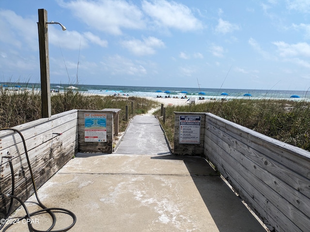 view of property's community with a beach view and a water view