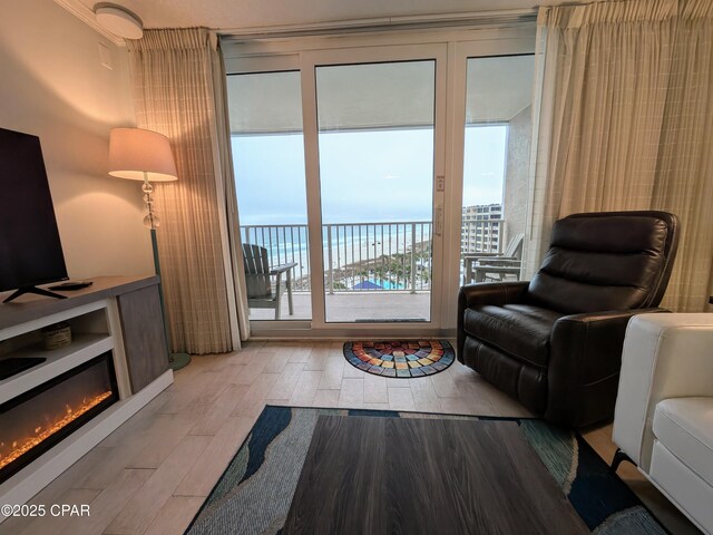 living room with a textured ceiling, a wall of windows, a water view, and a wealth of natural light