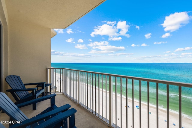 balcony featuring a beach view and a water view