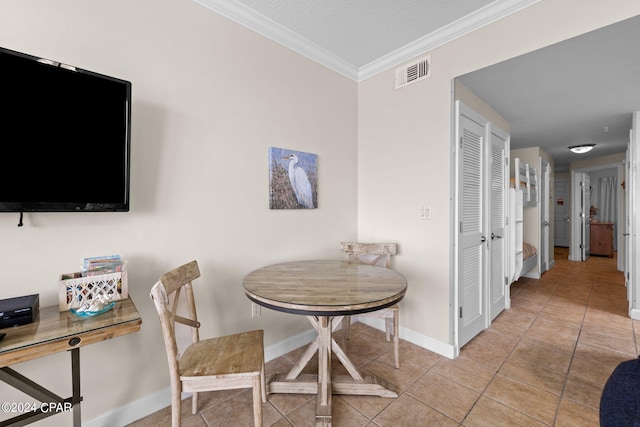 tiled dining room with crown molding and a textured ceiling