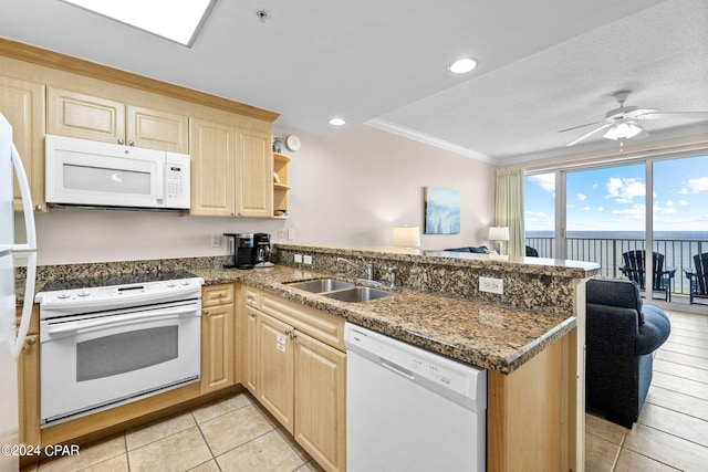 kitchen with sink, light brown cabinets, white appliances, and kitchen peninsula