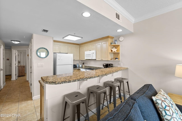 kitchen with light tile patterned floors, white appliances, stone counters, ornamental molding, and kitchen peninsula