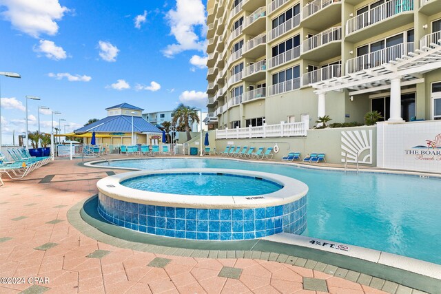 view of swimming pool featuring a hot tub, a gazebo, and pool water feature