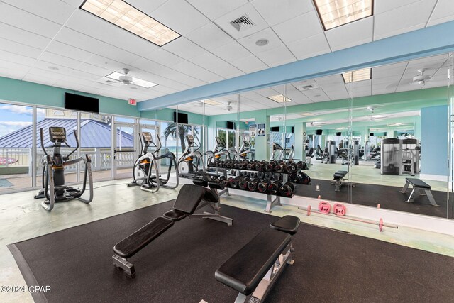 exercise room featuring ceiling fan and a paneled ceiling