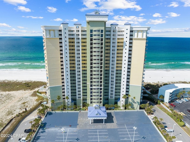 view of building exterior with a water view and a view of the beach