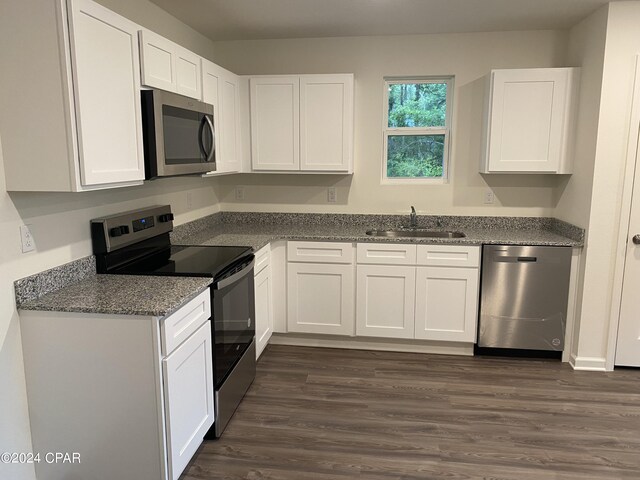 kitchen with appliances with stainless steel finishes, white cabinetry, and sink