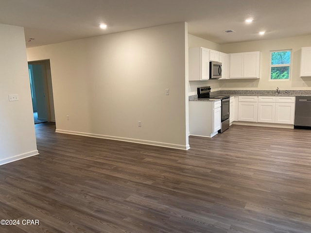 kitchen with dark hardwood / wood-style flooring, stainless steel appliances, and white cabinets