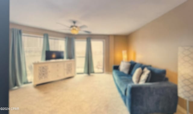 carpeted living room with ceiling fan