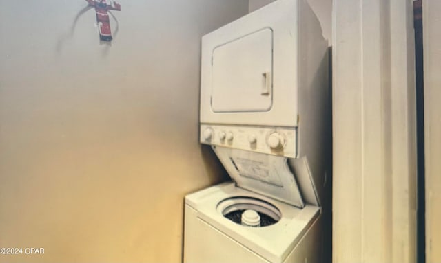 washroom featuring stacked washer and clothes dryer