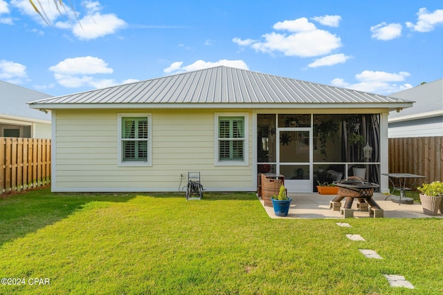 back of property featuring a patio, a yard, a sunroom, and a fire pit