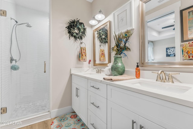 bathroom with hardwood / wood-style flooring, an enclosed shower, ceiling fan, and dual vanity