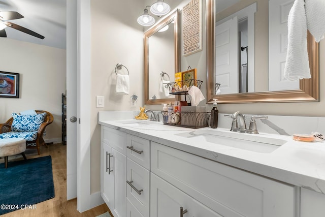 bathroom featuring hardwood / wood-style flooring, ceiling fan, and dual vanity