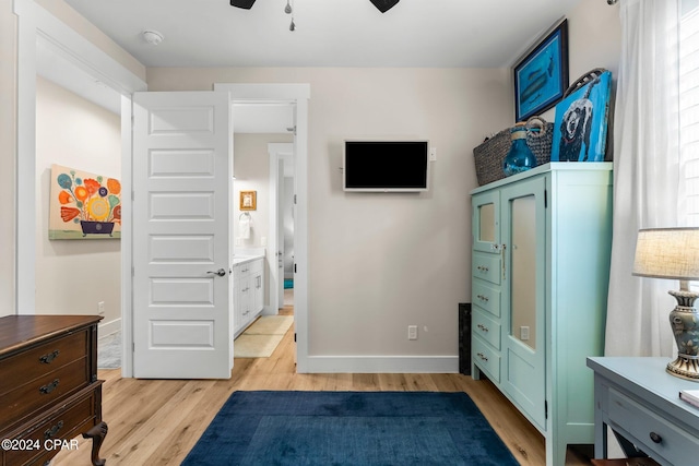 bedroom with ceiling fan, light wood-type flooring, ensuite bathroom, and multiple windows