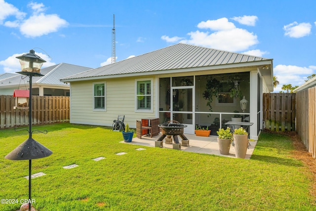 back of property with a patio area, a yard, and an outdoor fire pit