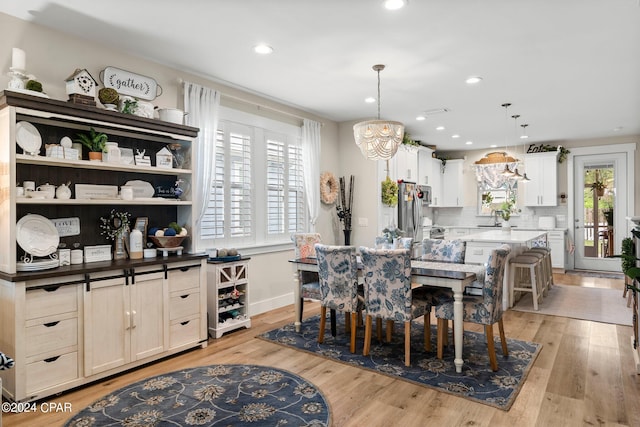 dining space with a healthy amount of sunlight, light hardwood / wood-style flooring, and sink