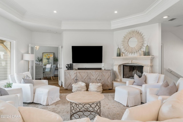 living room with a raised ceiling, hardwood / wood-style flooring, and ornamental molding