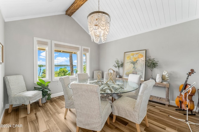 dining space featuring a notable chandelier, vaulted ceiling with beams, and light wood-type flooring