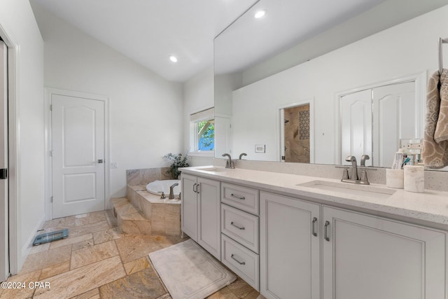 bathroom featuring tile floors, vaulted ceiling, double sink vanity, and independent shower and bath