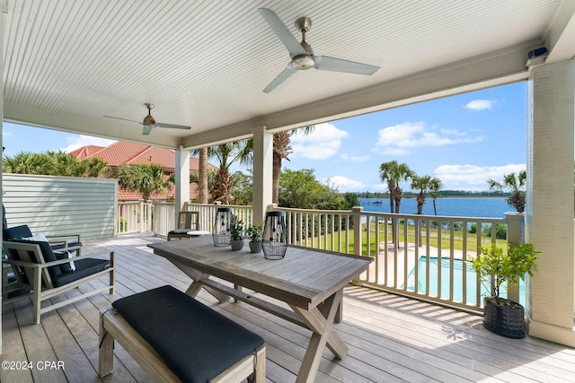 wooden terrace with a water view and ceiling fan