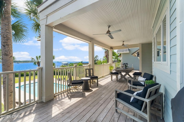 wooden deck featuring ceiling fan and a water view