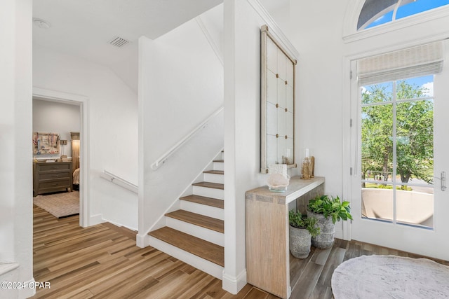 staircase featuring vaulted ceiling and hardwood / wood-style floors