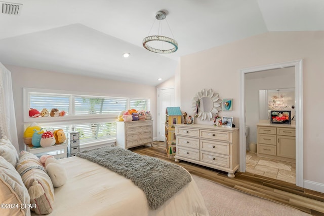 bedroom with lofted ceiling and light wood-type flooring