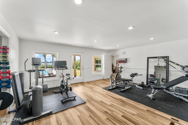 exercise room with light hardwood / wood-style flooring