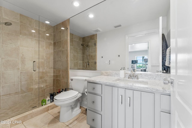 bathroom featuring tile floors, a shower with shower door, oversized vanity, and toilet