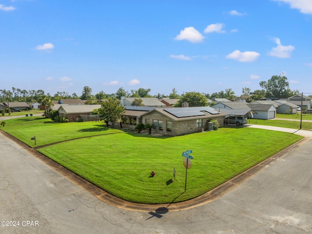 view of front of home featuring solar panels and a front yard