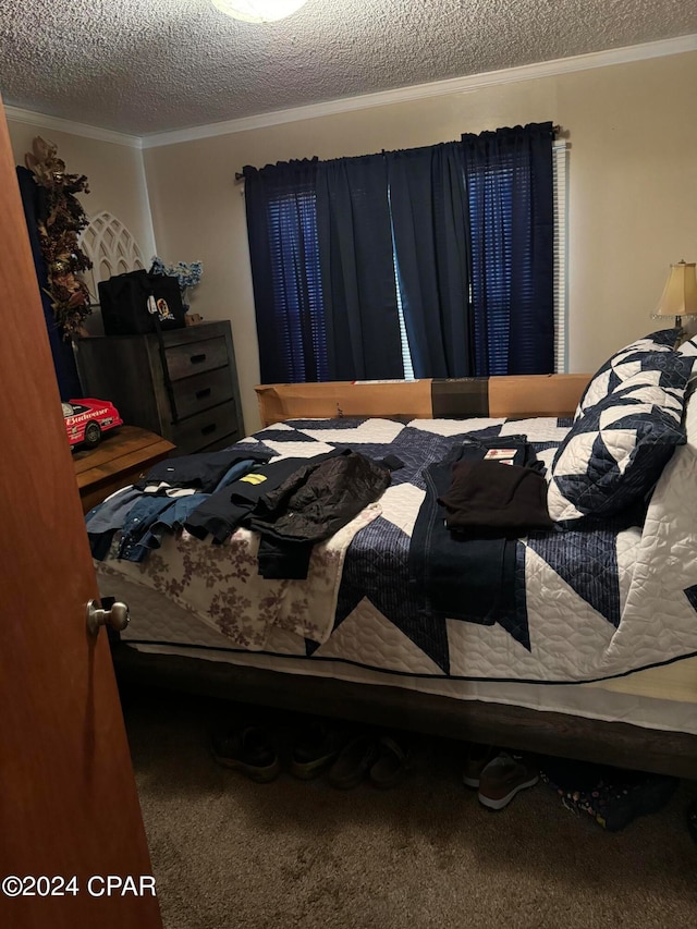 bedroom with a textured ceiling, crown molding, and carpet floors