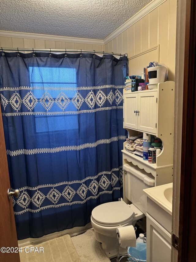 bathroom with a textured ceiling, a shower with shower curtain, toilet, vanity, and ornamental molding