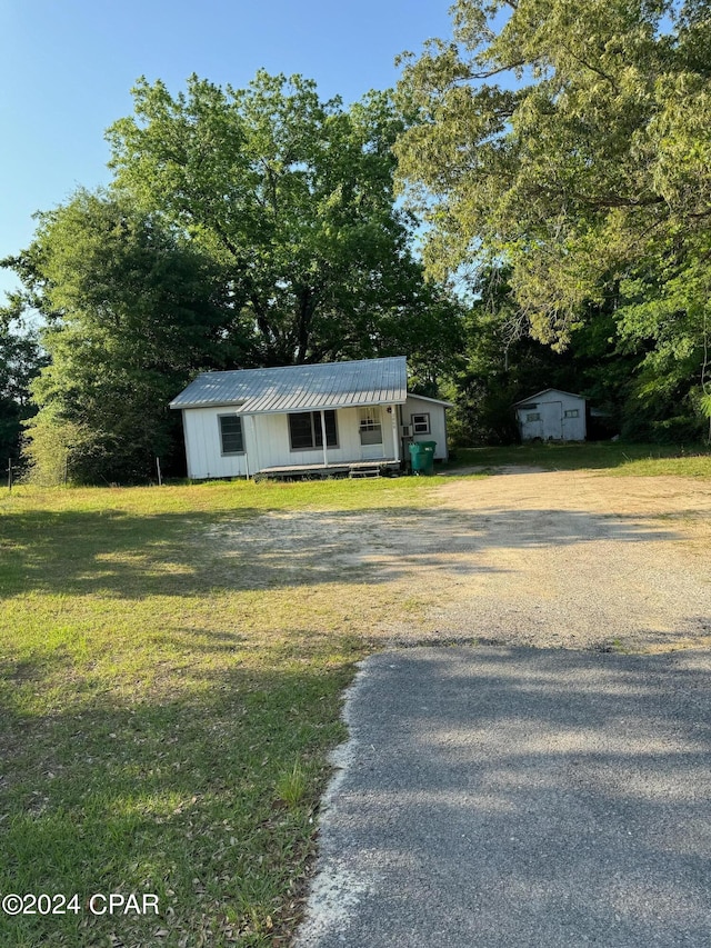 view of front facade featuring a storage shed and a front yard