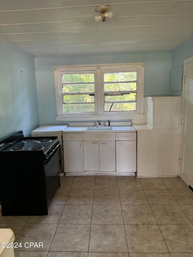 kitchen featuring white cabinetry, sink, electric range, and light tile patterned floors