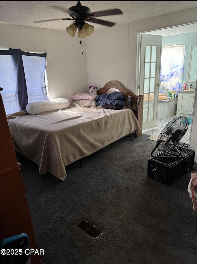 carpeted bedroom with ceiling fan and a textured ceiling