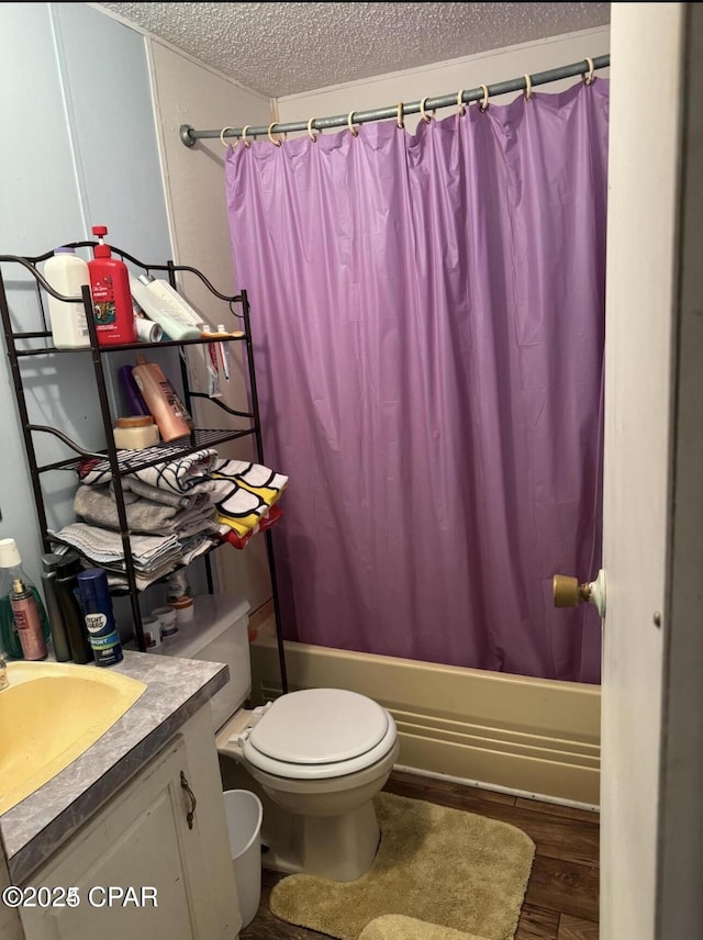 bathroom featuring a textured ceiling, toilet, shower / tub combo, wood finished floors, and vanity